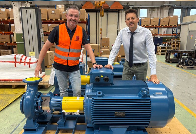 Mattias Steffl fra Colly Flowtech står sammen med Massimiliano Restelli fra Pompetravaini ved siden af en stor industripumpe inde i Pompetravainis produktionsanlæg.